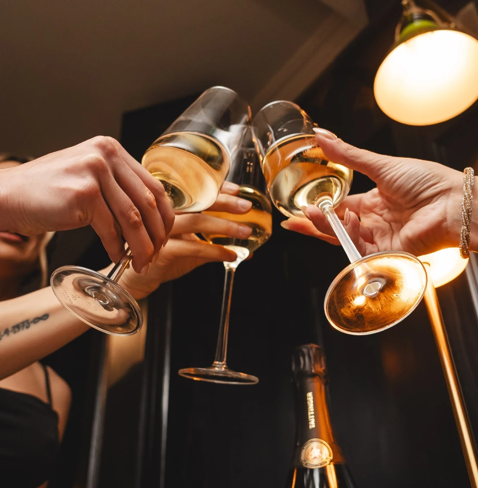 Tres personas brindado con tres copas de champagne francés.